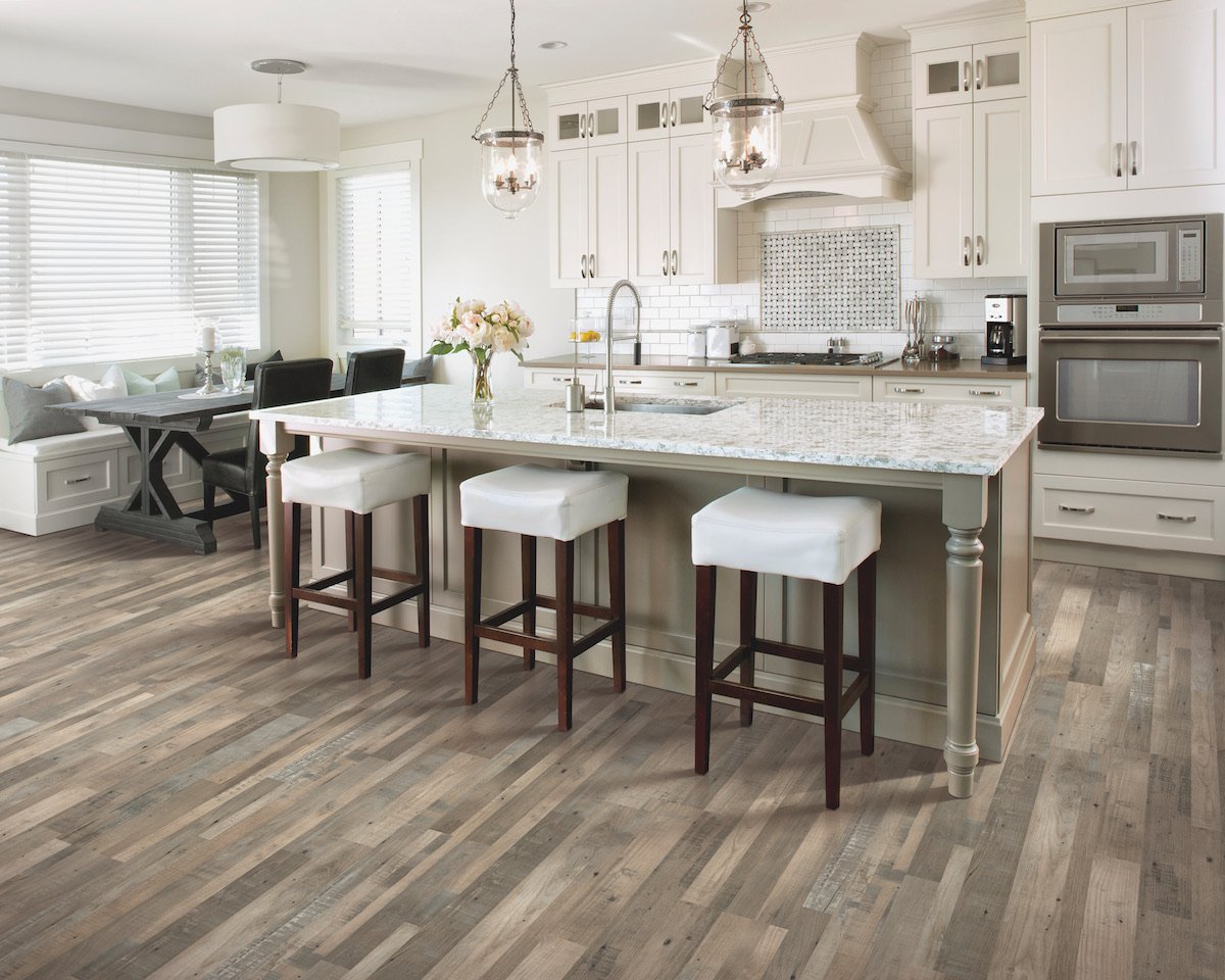 Kitchen with hard surface flooring, island with bar stools and tiled backsplash