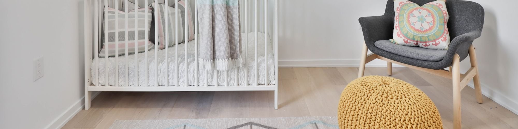 Nursery with baby crib and vinyl plank flooring